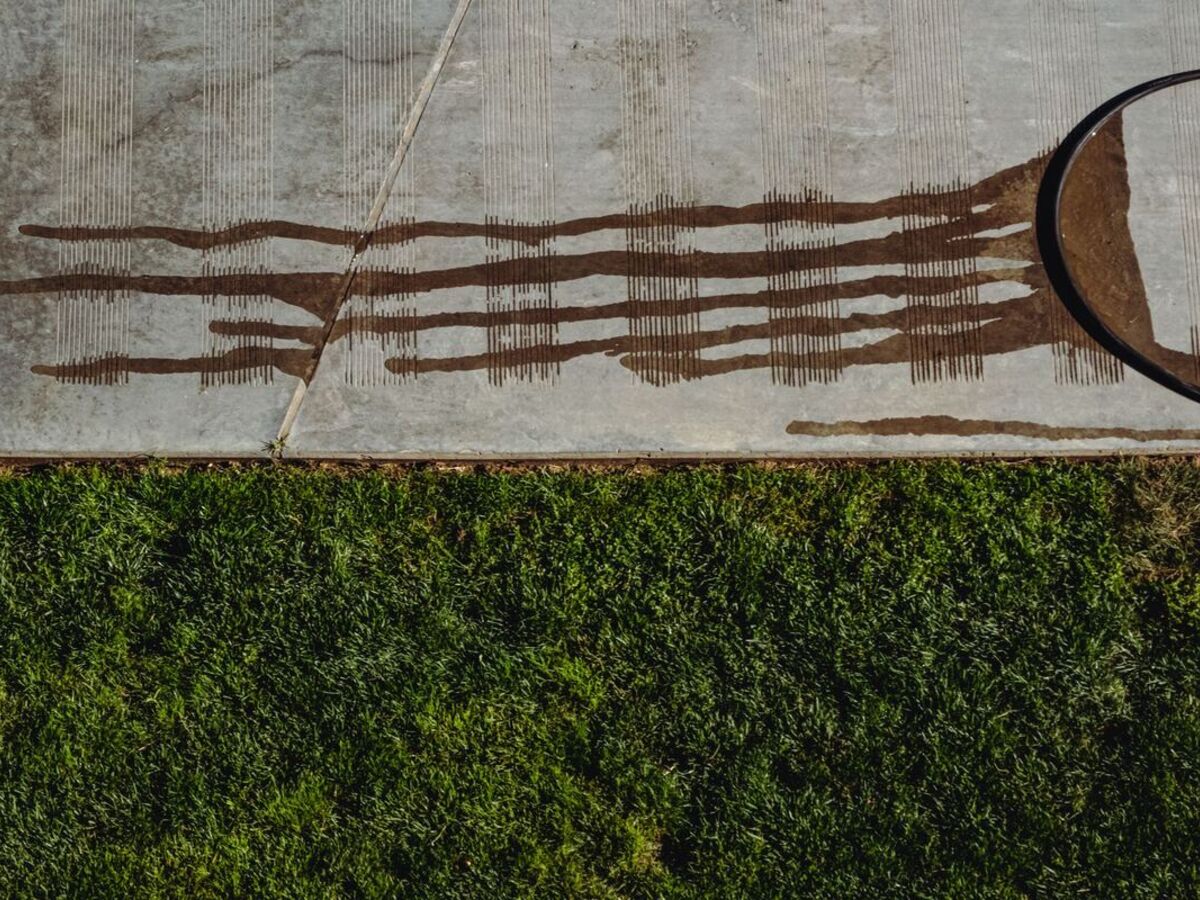 Freshly rinsed concrete beside a green lawn
