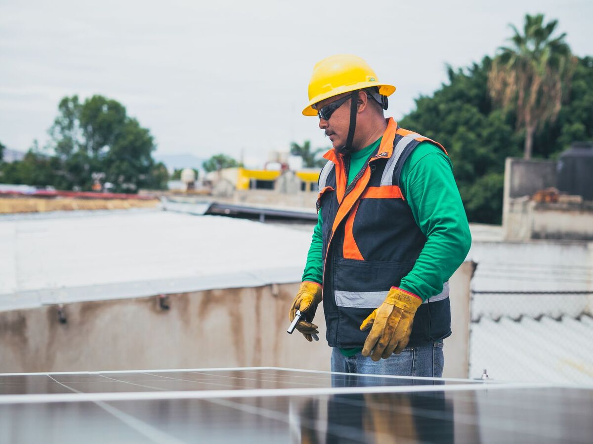 Technician checking rooftop solar panels